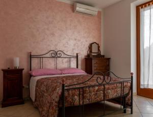 托里塔迪谢纳Casa in Chiana的一间卧室配有一张带粉红色枕头和镜子的床