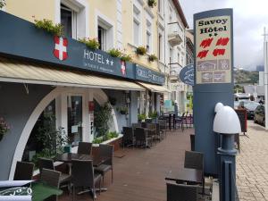 圣米歇尔德莫里耶讷Savoy Hotel & Restaurant的大楼里一条带桌椅的空街道