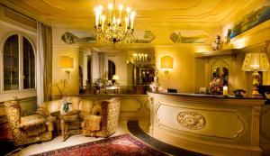 加尔多内-里维耶拉Park Hotel Ville Montefiori的客厅配有两把椅子和吊灯