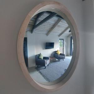 雷克赛德Lakeside Mountain Loft的镜子反射着客厅,客厅配有两把椅子和一张沙发