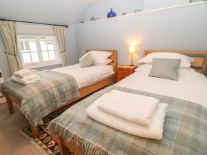 巴德利索尔特顿Robyn Cottage的一间卧室设有两张床和窗户。