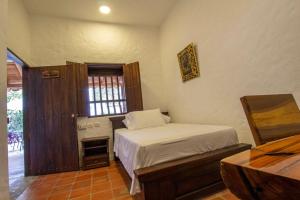 GarzónHotel Parque la Casona的一间卧室配有一张床、一张书桌和一个窗户。