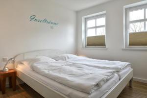 威克奥夫弗尔Stadtwohnung 1的带2扇窗户的客房内的一张白色床