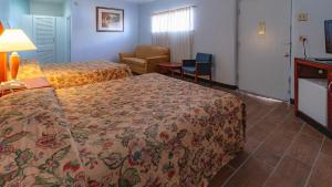 代顿Red Horse Motel Dayton Moraine的酒店客房设有两张床和一张桌子。