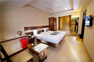 哥印拜陀HOTEL THE FORTUNE的酒店客房配有一张床铺和一张桌子。