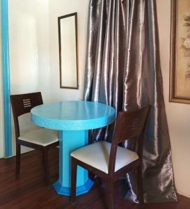 宿务RedDoorz Near Gaisano Grand Cordova的一张带两把椅子和镜子的蓝色桌子