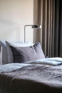 哥本哈根Hotel Ottilia by Brøchner Hotels的一间卧室配有带枕头和台灯的床