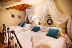 FumoneDimora di Charme Villa Sant'Erasmo的一间卧室配有两张带白色床单和蓝色枕头的床。