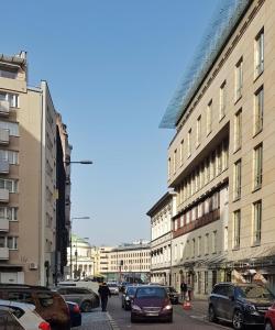 华沙Mokotowska 67 by Homeprime的一条城市街道上,街上有汽车停放