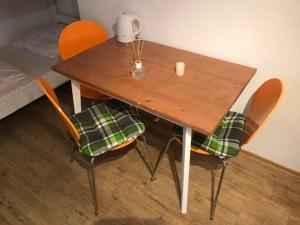 鲁斯特Gästehaus Europa的一张木桌,配有两把椅子和天花