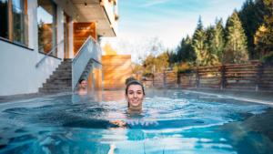 巴德小基希海姆特拉勒霍夫酒店的女人在游泳池游泳