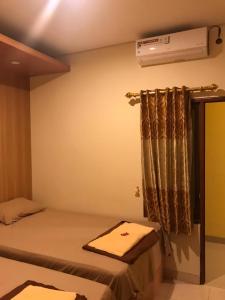 日惹Kangen Yogya Homestay Malioboro Mitra RedDoorz的卧室配有一张床,墙上配有空调