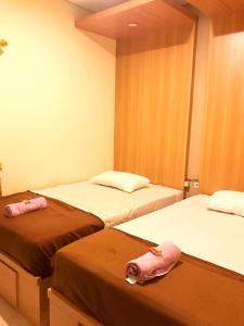 日惹Kangen Yogya Homestay Malioboro Mitra RedDoorz的客房内的两张床和两条粉红色的毛巾