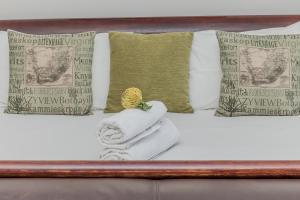 开普敦坎普斯湾51号酒店的一张带两条毛巾和枕头的床