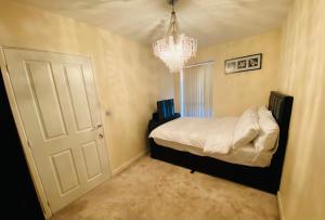 伯明翰Birmingham Guesthouse的卧室配有白色的床和吊灯。
