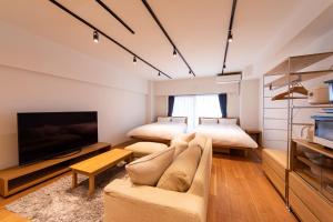 东京NIYS apartments 08 type的客厅配有两张床、一张沙发和一台电视