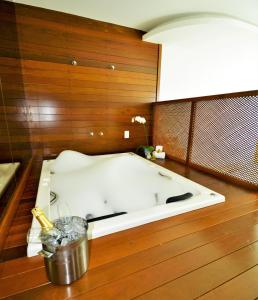 卡波布里奥Oasis Cabo Frio的木墙客房内的浴缸