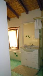 穆拉沃拉Il Portico Guesthouse的一间带水槽和镜子的浴室以及窗户。