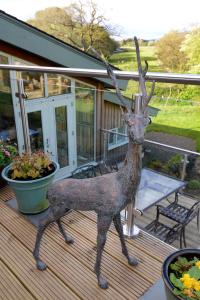 Newcastleton布莱克伯恩住宿加早餐旅馆的登上甲板的鹿雕像