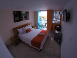 基布多Kamaleb Farallones Hotel的一间带大床的卧室和一个阳台