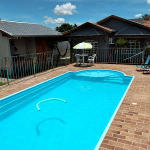 大坎普Pousada e Hotel Italian Garden House的一座大蓝色游泳池,位于房子前