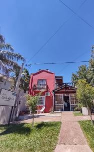 科隆Posada Costa del Sol的一间红色和白色的房子,前面有标志