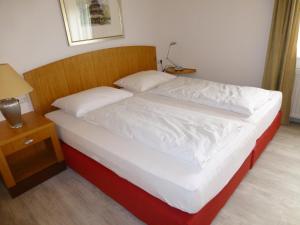 林道布里艮住宿加早餐酒店的一张铺有白色床单的床和木制床头板