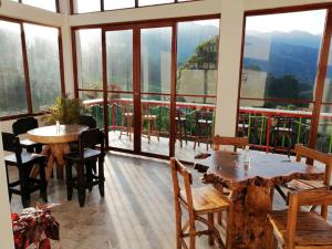 萨兰托Hotel Salento Mirador的用餐室设有桌椅和窗户。