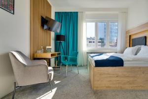 萨格勒布Bed & Breakfast Sky City Center的酒店客房配有一张床、一张书桌和一台电视。