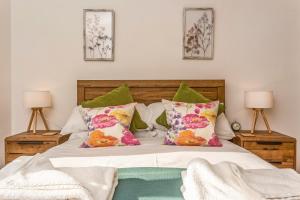 水上伯顿Ardenlea的一间卧室配有带绿色和粉红色枕头的床