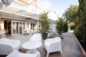 卡尔维Campo Di Fiori, Maisons de Charme的木制甲板上配有白色椅子和桌子的庭院