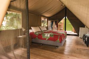 拉罗汤加伊库拉吉环保帐篷酒店的帐篷内一间卧室,配有一张床
