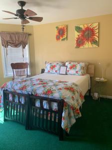摩押Moab Beds Xpress Inn的一间卧室配有一张带被子的床和风扇