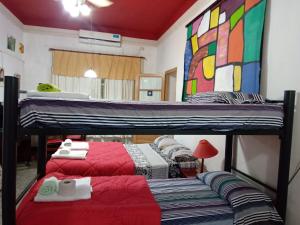 罗萨里奥EnmicasaSSJ-Rosario的一间卧室配有两张双层床,铺有红色床单