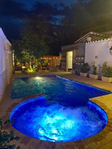 圣菲德安蒂奥基亚Casa Bixa Hotel Boutique - Solo Adultos的后院的泳池,晚上有蓝色的灯光