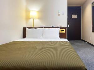 松本松本潮流酒店的一张位于酒店客房的床铺,配有一张大床
