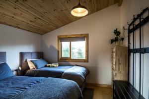 Saint FlorenceFern Lodge - 2 Bedroom Log Cabin - Saint Florence - Tenby的一间卧室设有两张床和窗户。