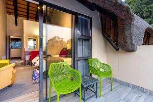 伯格维尔Cavern Resort & Spa的庭院里设有两把绿色椅子和一张桌子