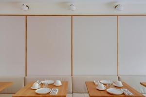 圣艾米隆Badon Boutique Hotel的一间用餐室,配有两张带盘子和玻璃杯的桌子