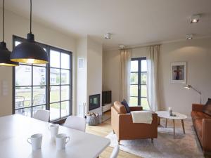 德兰斯克Reetland am Meer - Premium Reetdachvilla mit 3 Schlafzimmern, Sauna und Kamin E16的客厅配有沙发和桌子
