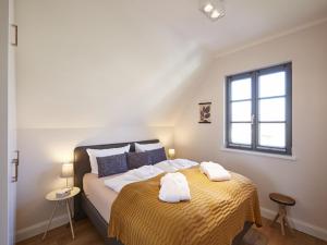 德兰斯克Reetland am Meer - Premium Reetdachvilla mit 3 Schlafzimmern, Sauna und Kamin E16的一间卧室配有一张床,上面有两条毛巾