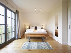德兰斯克Reetland am Meer - Premium Reetdachvilla mit 3 Schlafzimmern, Sauna und Kamin E19的一间卧室设有一张床和一个大窗户