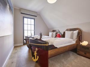 德兰斯克Reetland am Meer - Luxus Reetdachvilla mit 3 Schlafzimmern, Sauna und Kamin E27的阁楼上的卧室配有两张床