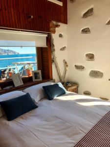 蒙特罗索阿尔马雷德尔多甘尼耶度假屋的一间卧室设有两张床,墙上设有一扇带岩石的窗户。