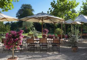 苏西Romantik Hotel de L'Ours的一组桌椅,配有遮阳伞和鲜花