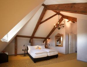苏西Romantik Hotel de L'Ours的阁楼卧室配有白色床