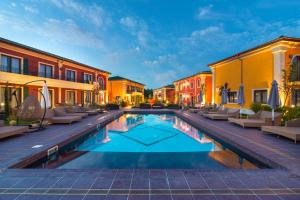 克兰内沃Luxury Villas in Therma Village - Mineral Pool & SPA的庭院内的游泳池,设有椅子和建筑