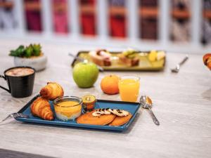 佩皮尼昂ibis Styles Perpignan Centre Gare的桌上的一小盘食物和橙汁