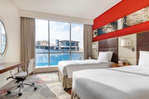多哈多哈皇冠假日酒店 - 商业公园的酒店客房设有两张床和大窗户。