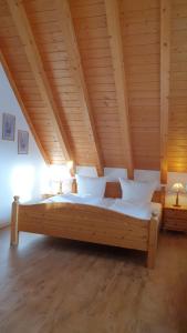 霍伊塞尔恩Landgasthof zum Dorfkrug的一张位于带木制天花板的客房内的大床